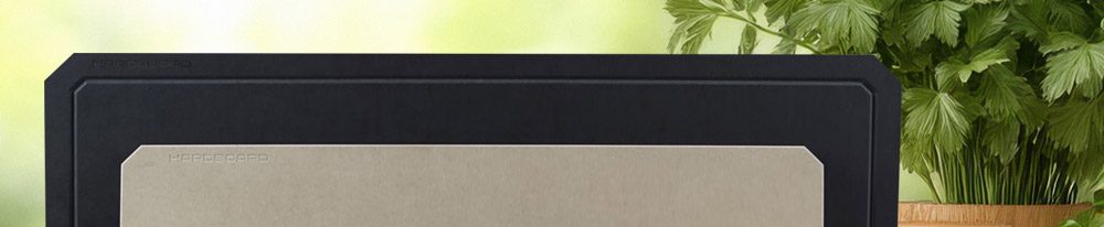 HARDBOARD Schneidebretter in verschiedenen Größen, elegant präsentiert vor frischen Kräutern.
